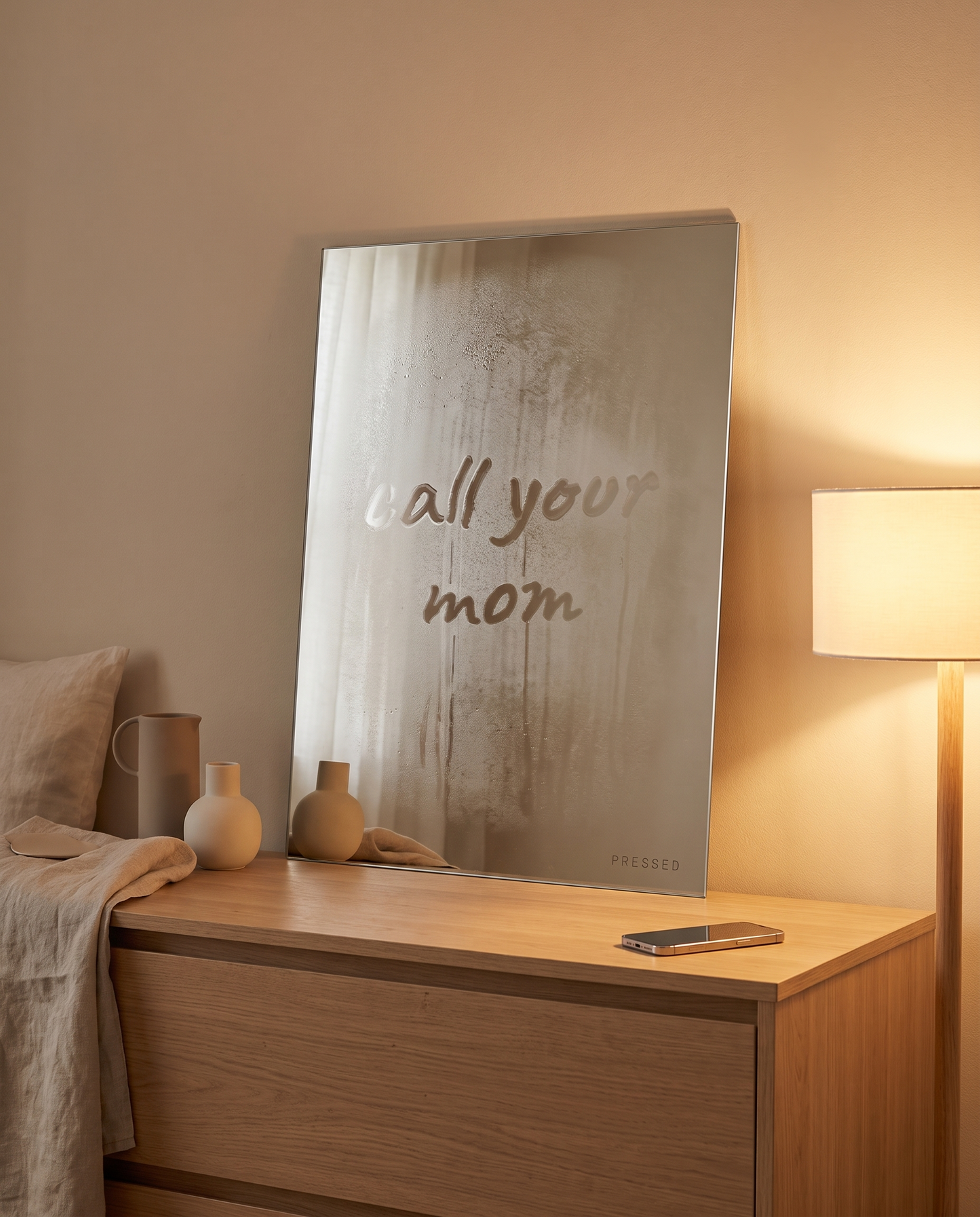 Fogged mirror with 'call your mom' wiped clear, in a bedroom